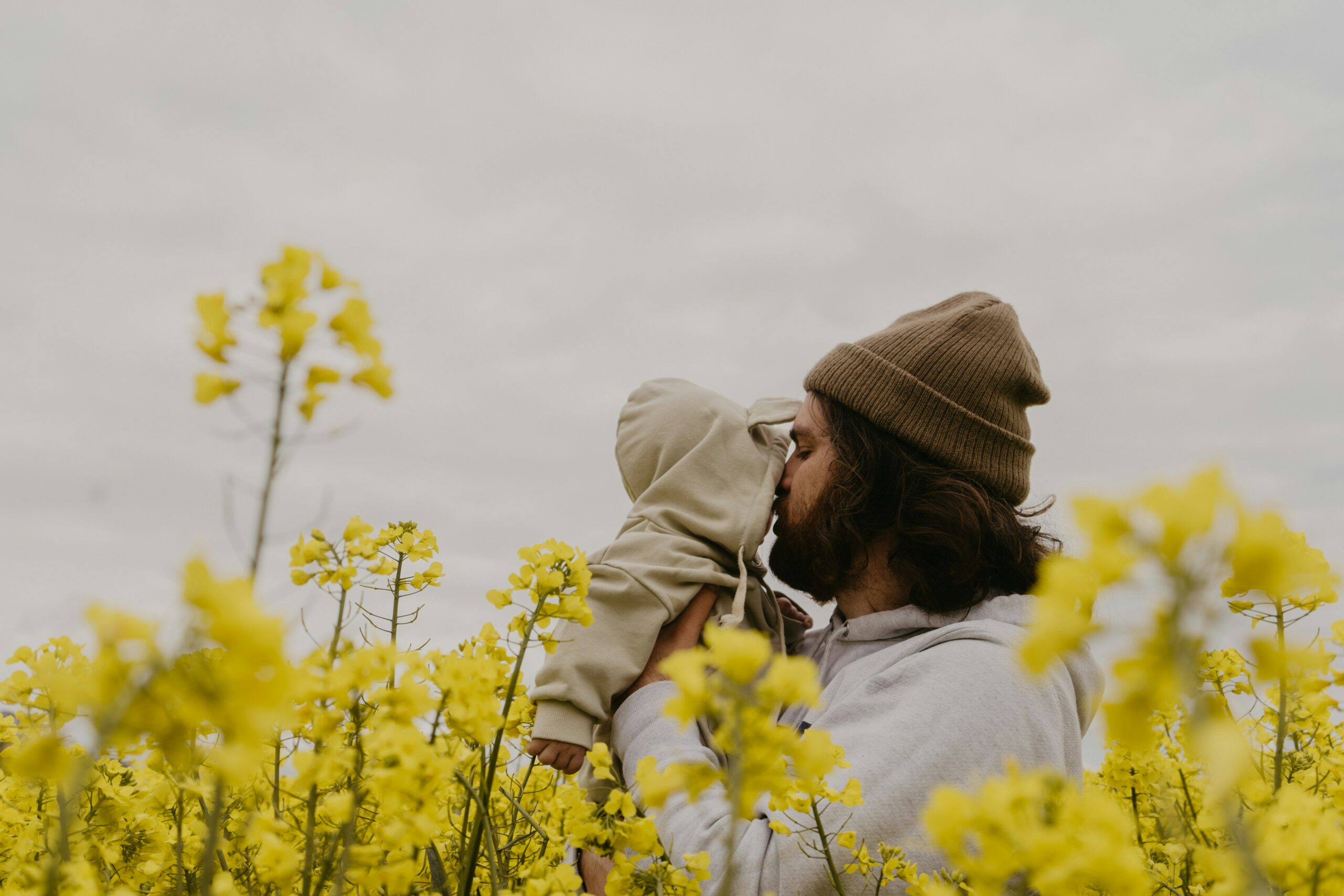 Babalık Erkeklerin Beynini Nasıl Değiştiriyor? Araştırma Bulguları a man and woman kissing in a field of yellow flowers