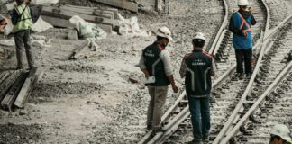 2023 Yılında İş Kazaları ve İş Cinayetlerinde Endişe Verici Artış a group of people standing on top of train tracks