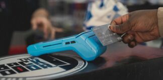 Türkiye’de Kartlı Ödemelerin Artan Trendi ve Ekonomik Yansımaları a person holding a blue object in their hand