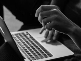 grayscale photo of person using MacBook