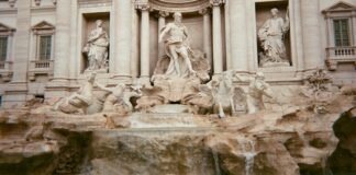 Trevi Çeşmesi Yenilendi: 2025 Kutsal Yılına Doğru Yenilikler a fountain in front of a building with statues on it