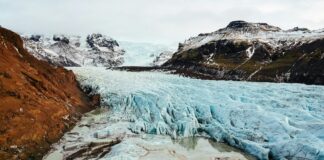 Dağların Sessiz Çığlığı: Buzulların Erimesinin Mikro Depremlere Etkisi frozen river in the middle of rock mountains