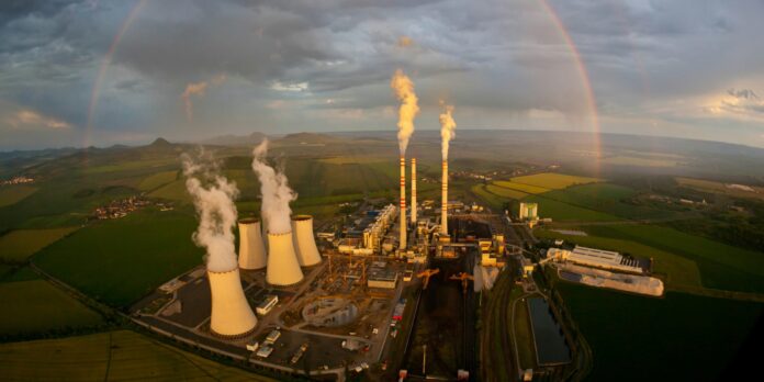 a large factory with a rainbow in the background