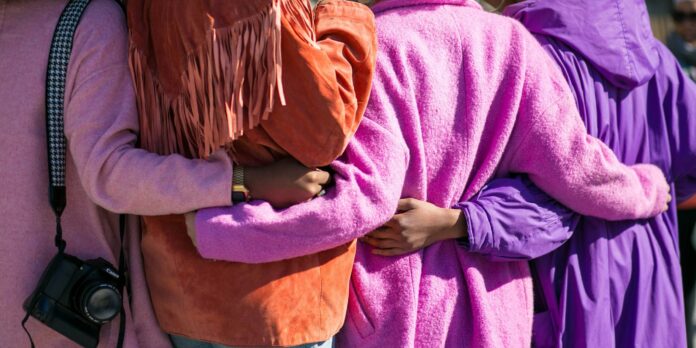 four person holding each others waist at daytime